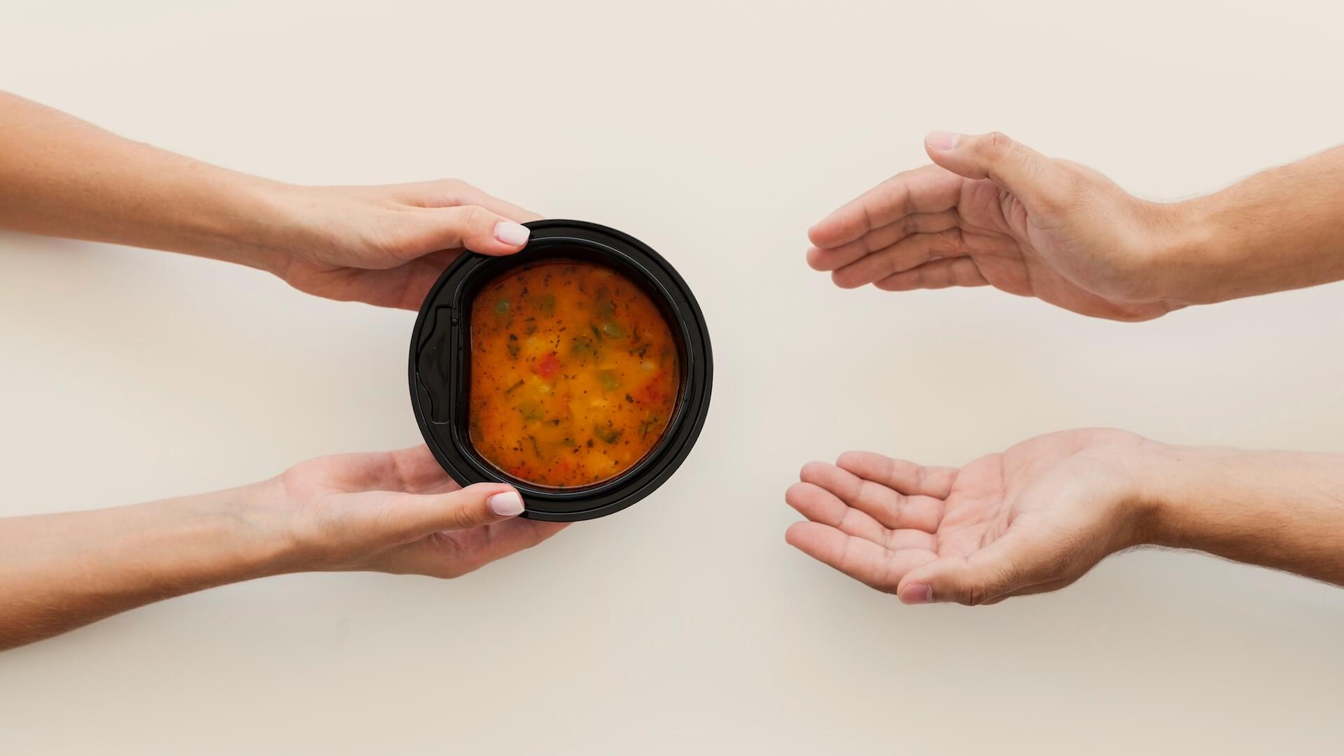 Hands passing a nourishing meal from one person to another